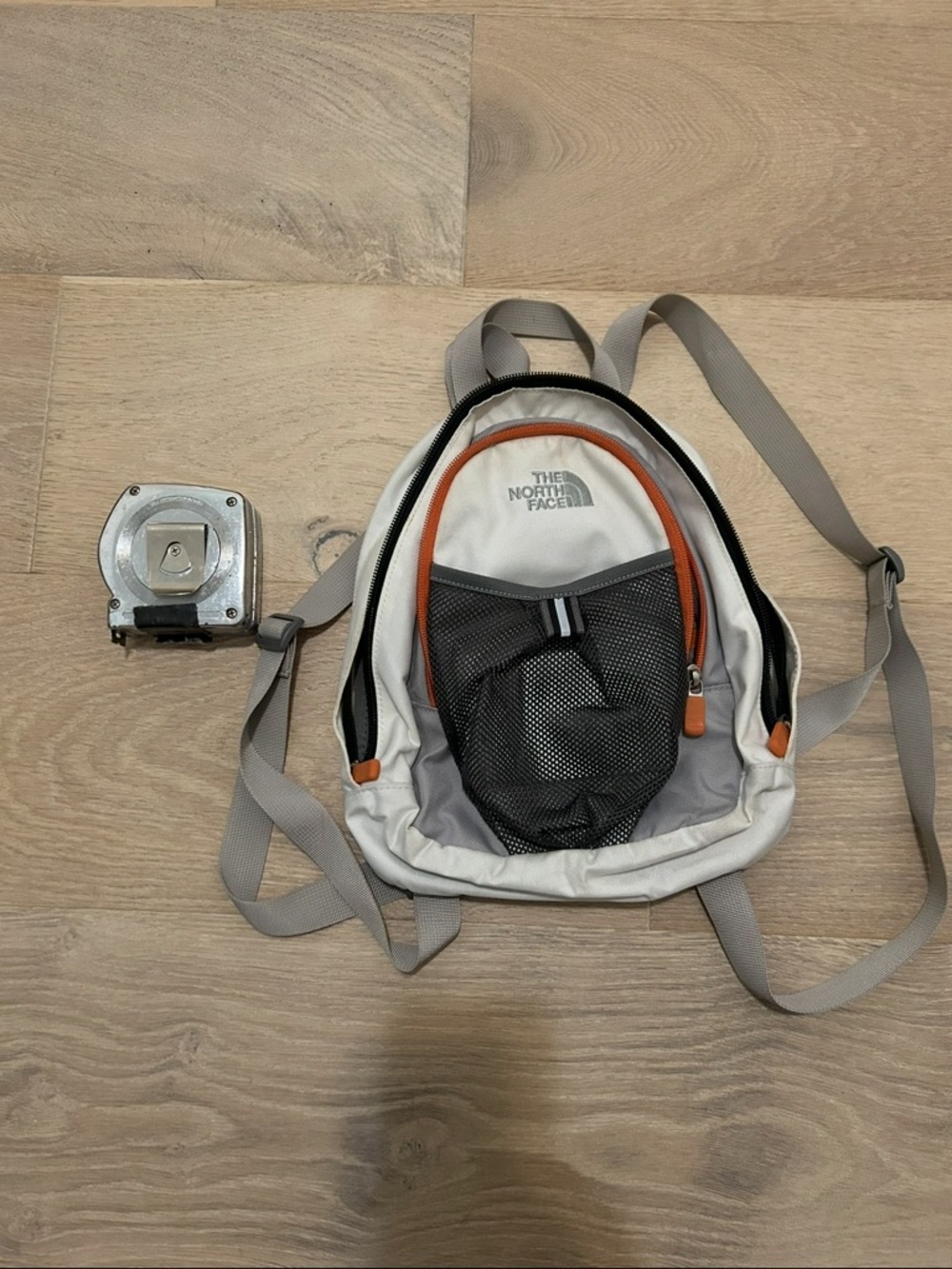 The North Face Mini Backpack in Light Gray with Orange Accents